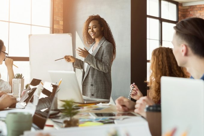 Cheerful businesswoman giving presentation to group