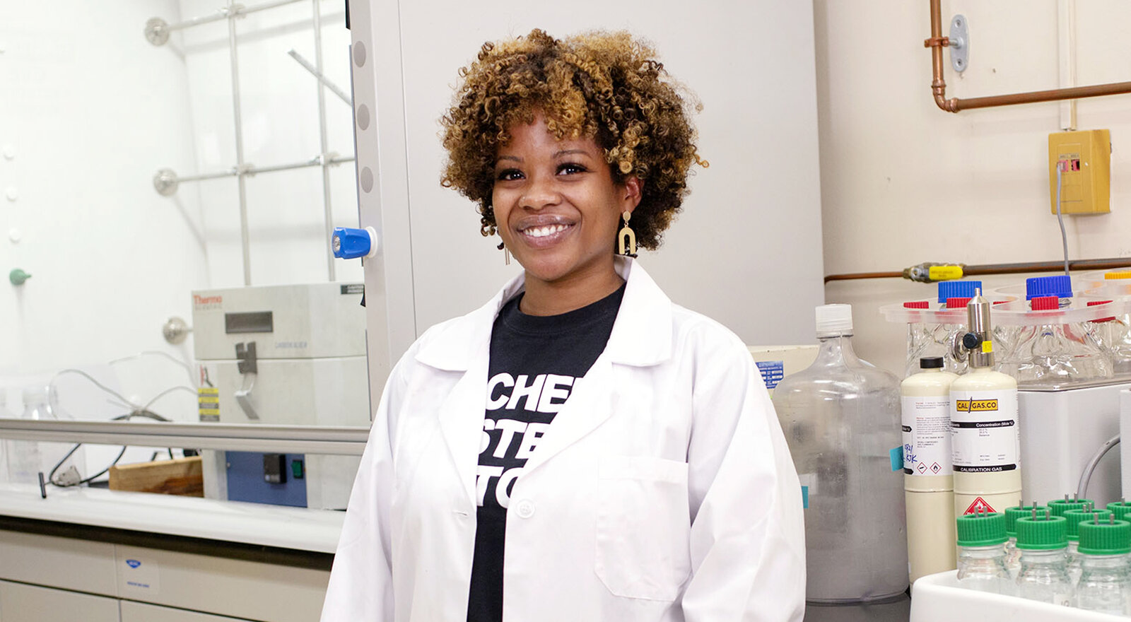 student poses in a white coat
