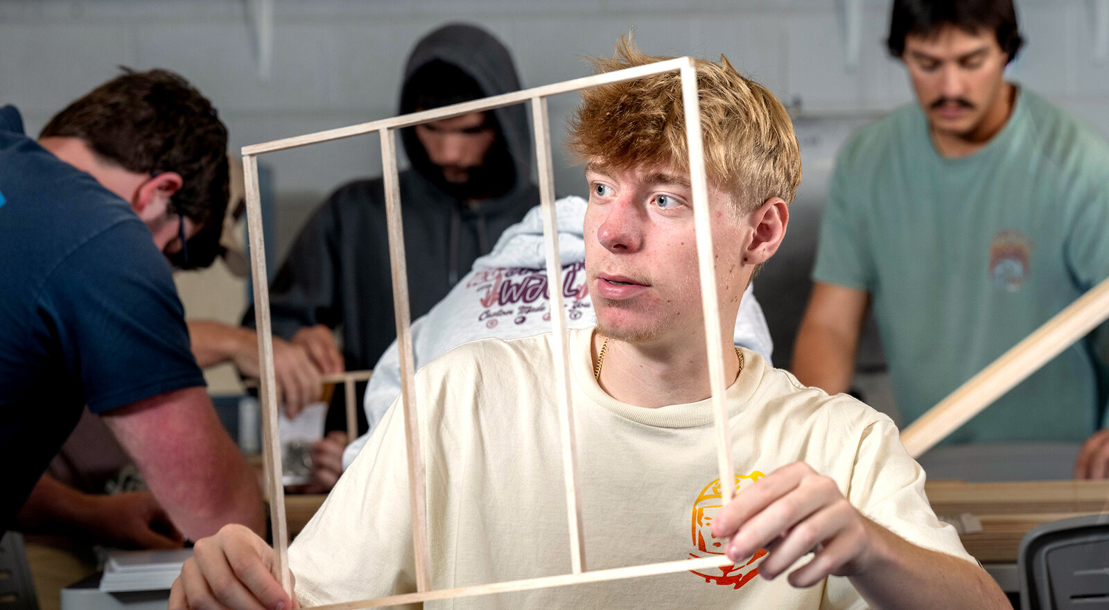 student holds a wooden model