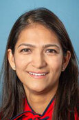 Dr. Patel has long, straight dark hair, is wearing a bright  red shirt